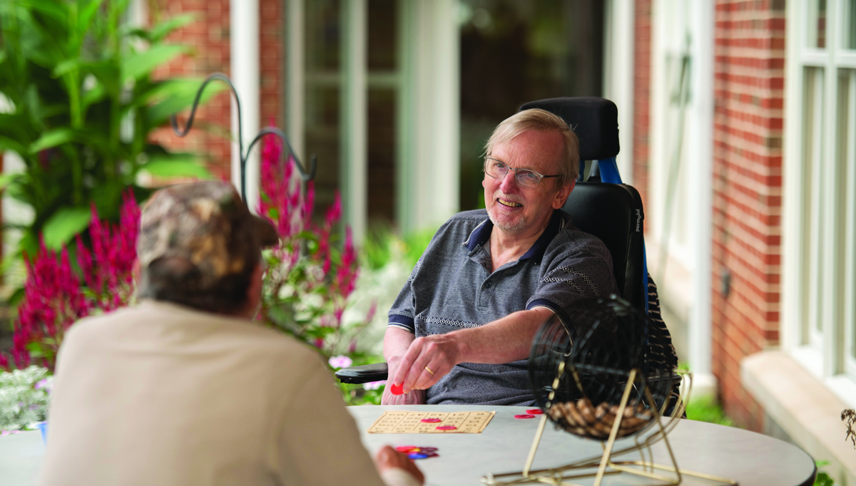 two seniors talking at kitchen table