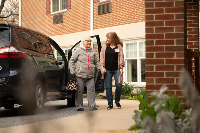 Caregiver helping senior from car