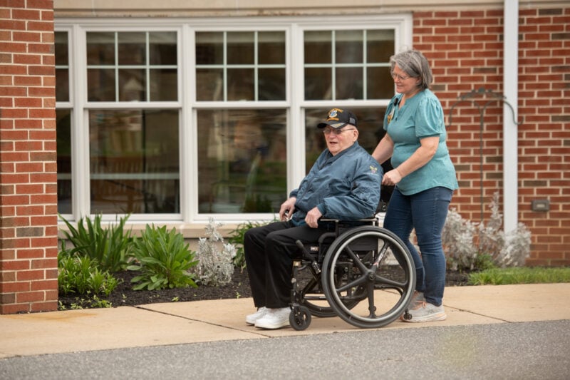 Female pushing male in wheelchair